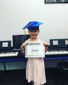 Bach to Rock student Avery W holding diploma